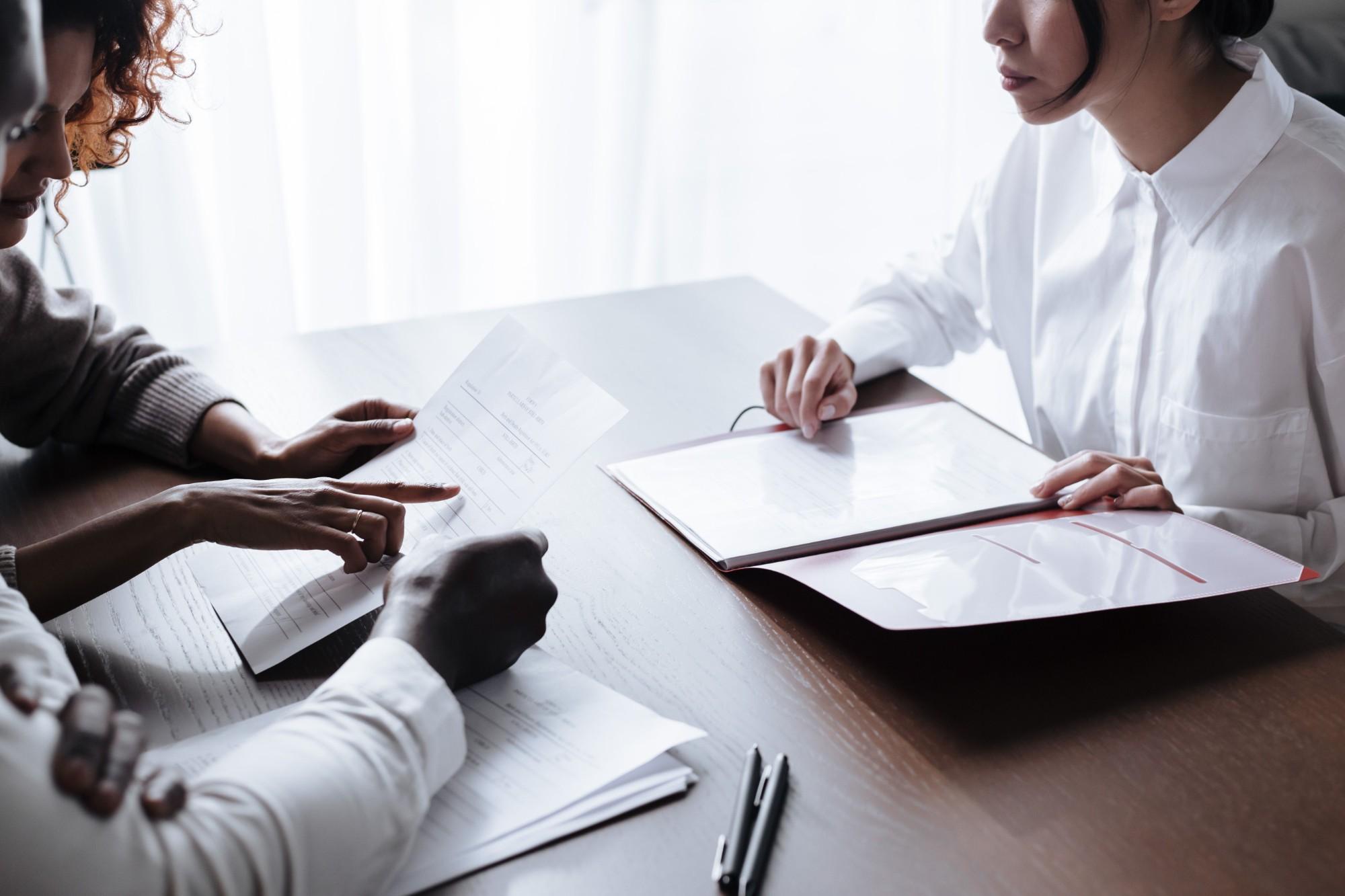 Professionals reviewing settlement documents across a table